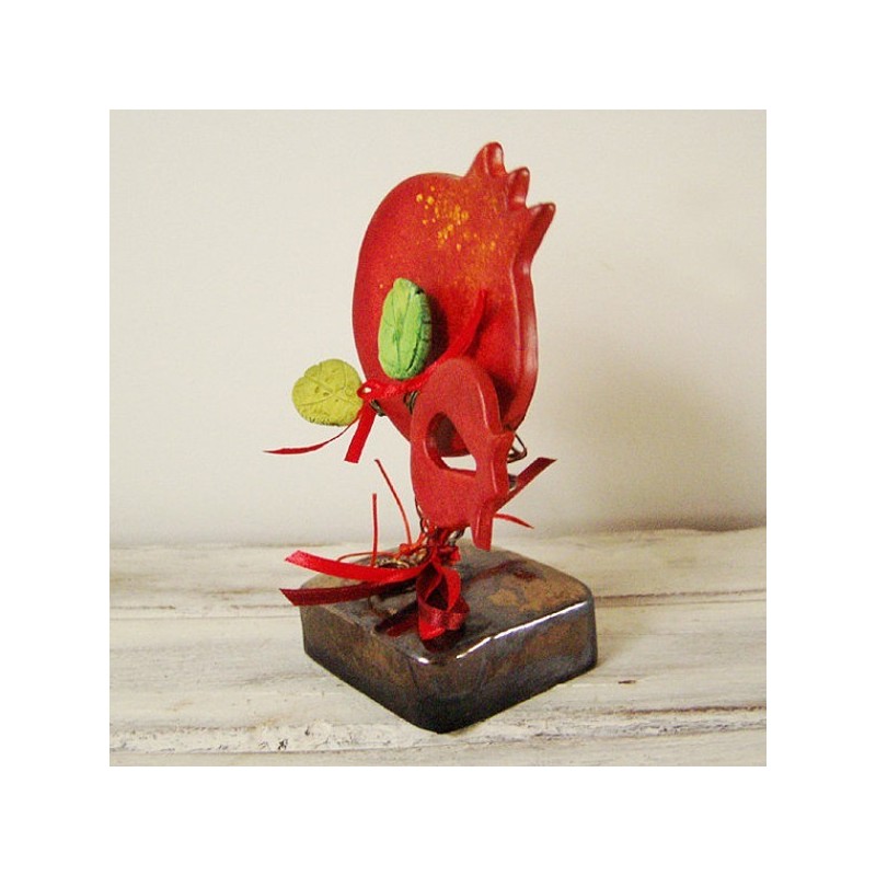 Red pomegranates sculpture, set of two pomegranates on brown, square base with green leaves and ribbons