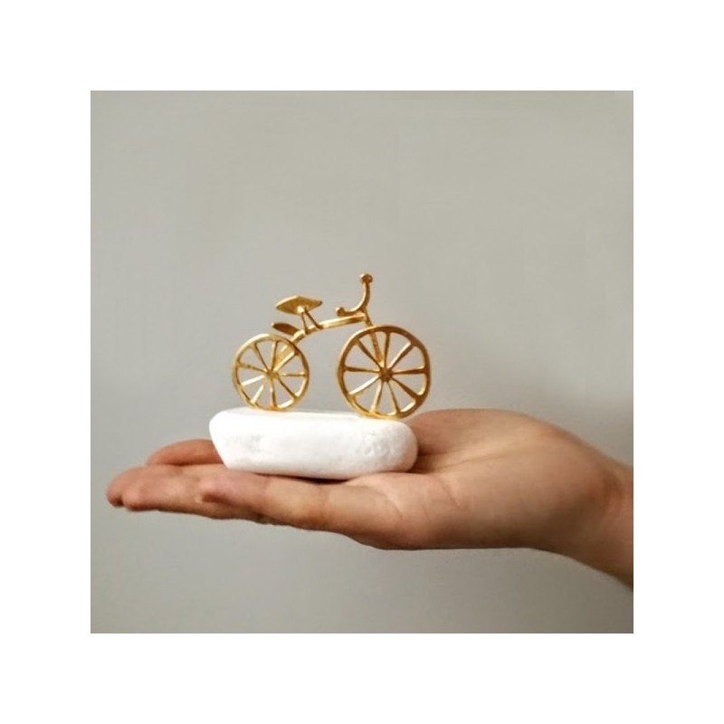 Gold bicycle sculpture, miniature bike sculpture on white stone, gold bike on white stone.