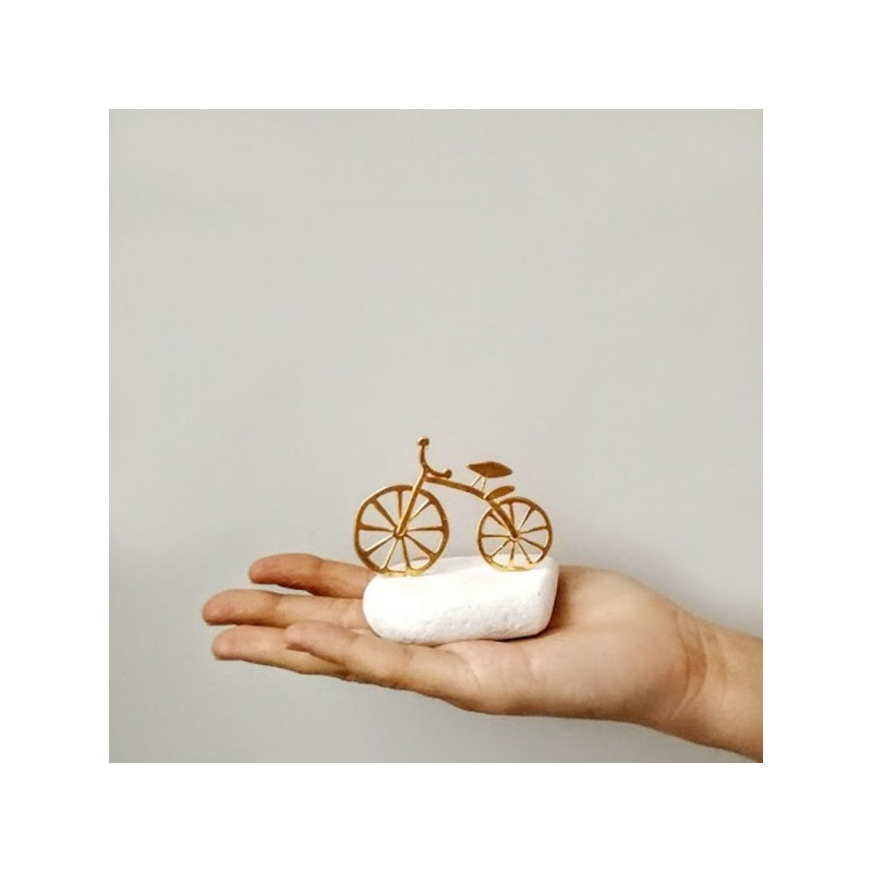 Gold bicycle sculpture, miniature bike sculpture on white stone, gold bike on white stone.