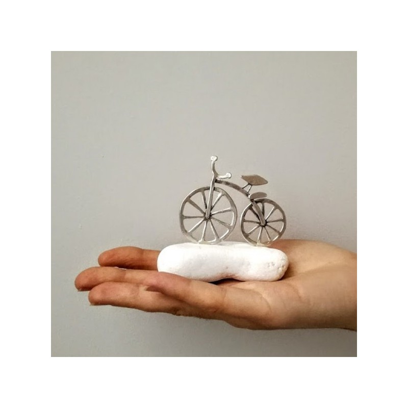 Silver bicycle sculpture, mini bike sculpture on white stone, silver bike on white stone.
