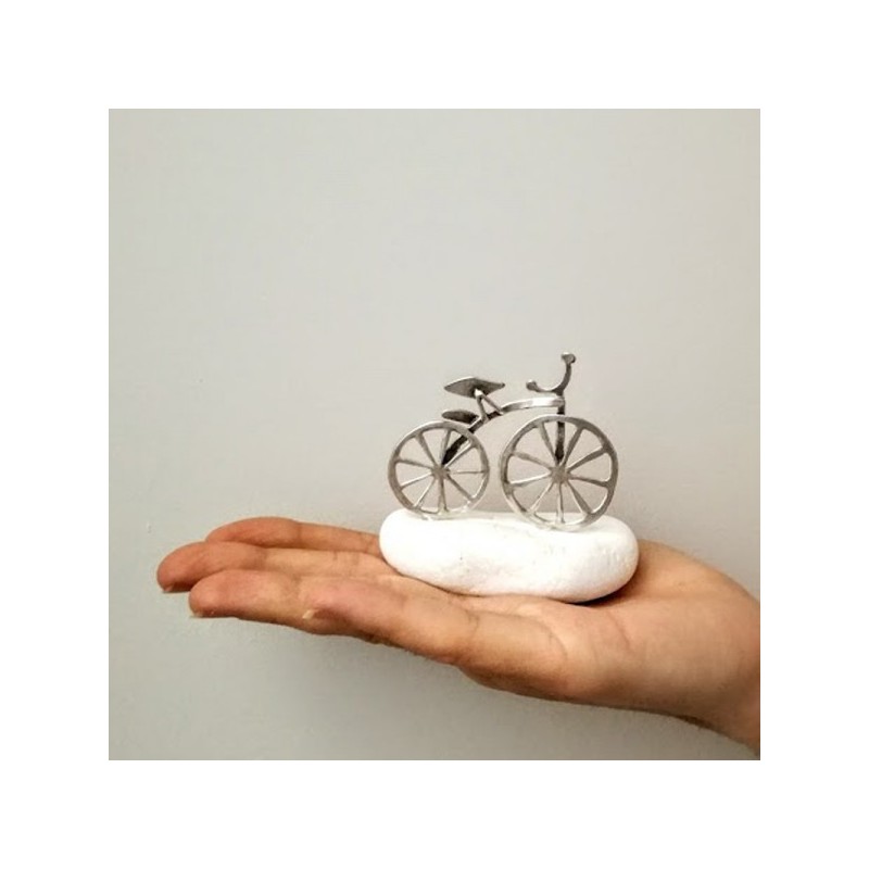 Silver bicycle sculpture, mini bike sculpture on white stone, silver bike on white stone.