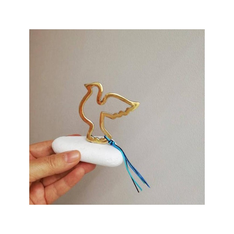 Flying bird sculpture, brass bird outline on white marble stone, gold dove sculpture on stone