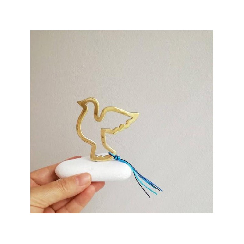 Flying bird sculpture, brass bird outline on white marble stone, gold dove sculpture on stone