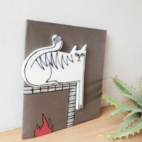 White cat wall hanging, porcelain cat in grey background, square wall tile of stoneware and porcelain, cat on the fireplace 2