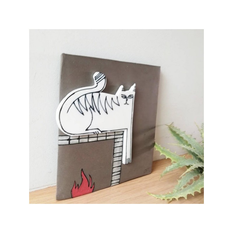 White cat wall hanging, porcelain cat in grey background, square wall tile of stoneware and porcelain, cat on the fireplace
