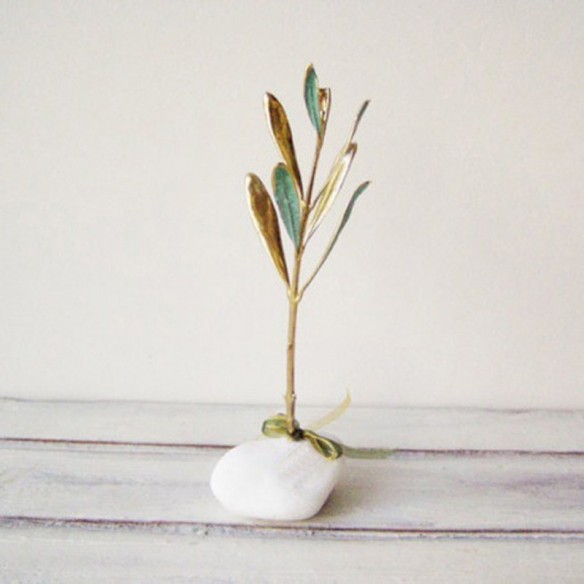 Olive branch lucky charm, New Year's good luck charm of olive tree twig on white pebble with 26 charm