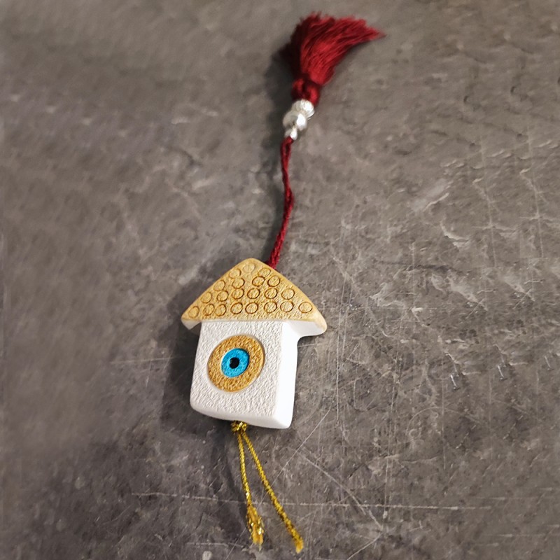 This is a small, ceramic house ornament of earthenware clay