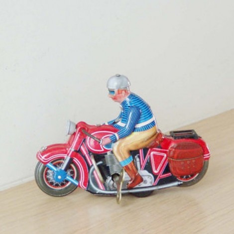 Wind up biker toy of a vintage, red motorcycle, with rider in blue jacket and grey helmet.