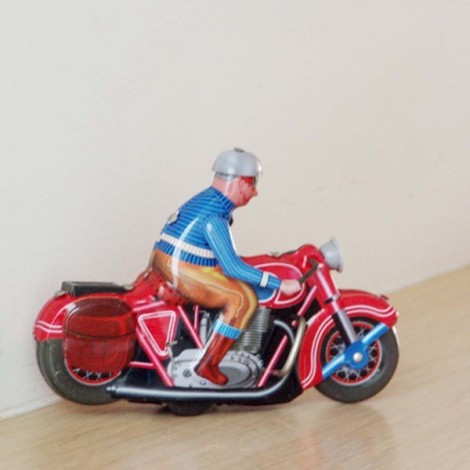 Wind up biker toy of a vintage, red motorcycle, with rider in blue jacket and grey helmet. 2