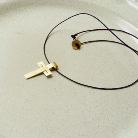Minimal solid gold cross, modern, unisex, 18 karat gold cross  on a black cord. 2