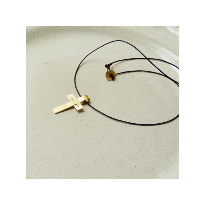 Minimal solid gold cross, modern, unisex, 18 karat gold cross  on a black cord.